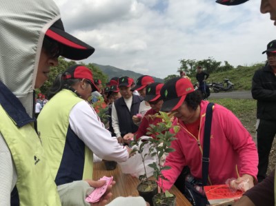 民眾帶著象徵「長壽」與「富貴」的茶花及桂花回家栽種，響應今年國際森林日的「森林與永續城市」