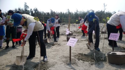 用鏟子努力種下海岸樹苗