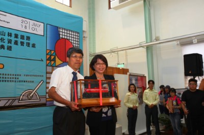 前森鐵處長林治平(左)將小火車交由林鐵及文資處長黃妙修(右)