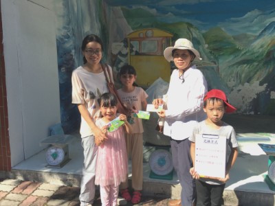 民眾帶著由住家周遭移除的小花蔓澤蘭來兌換小花代幣