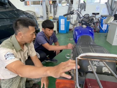 森林護管員陳俊宏與學生相互交流機車維修訣竅。