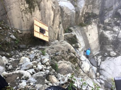 搬運大型貓坑材料走過崩塌地