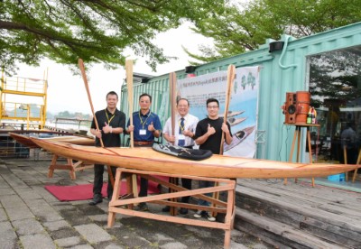 左起屏科大木設系龍暐助理教授、屏東林區管理處張偉顗處長、屏科大戴昌賢校長、屏科大木設系碩士班研究生余浤銓同學共同與「國產木竹材質獨木舟」合影