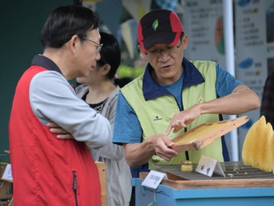 呂坤旺(右)至戶外擺攤為民眾介紹蜜蜂生態。