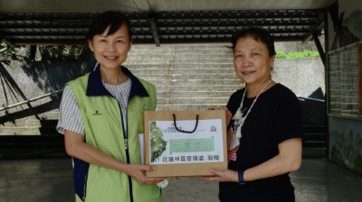 花蓮林區管理處秘書余蘭君(左)代表將圖書贈與文蘭國小，由教導主任蔡老師(右)代表接受。