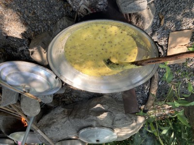 部落在鍋爐邊手搖烹煮小米樹豆粥