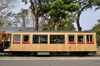 02-車廂外觀採用大片式的台灣檜木板材，搭配深邃的黑色窗框，並在車身側面以經典紅色點綴。