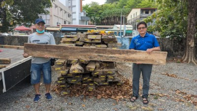 屏東林管處旗山工作站主任林弘基(右)親自移交木料予萬安國小何富強木雕老師提供學校運用2