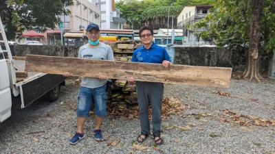 屏東林管處旗山工作站主任林弘基(右)親自移交木料予萬安國小何富強木雕老師提供學校運用