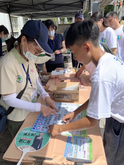 廉政志工與民眾互動介紹闖關遊戲規則及宣導反賄選(林業保育署新竹分署提供)