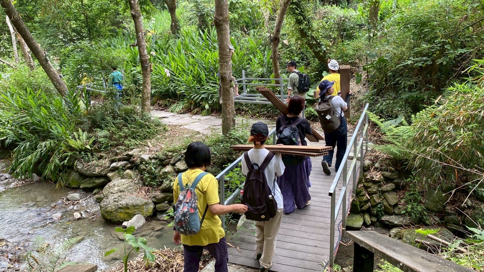 參與工作假期之日本大學生，刻正搬運生態廁所材料經過玉龍泉